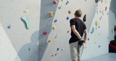 A man is climbing on a climbing wall photo