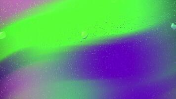 Water droplets capture a vivid green and purple background, perfect for abstract designs, naturethemed concepts, or refreshing visuals in various projects. video