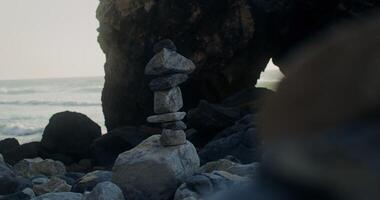 A stack of rocks on the beach near the ocean photo