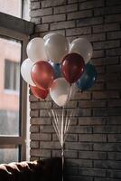 Colorful balloons grouped together in front of a rustic brick wall, creating a festive and vibrant atmosphere photo