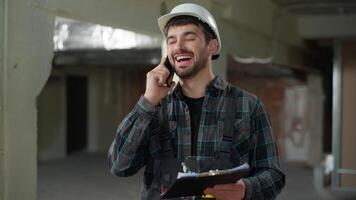 Man builder engineer talking mobile phone building industry smiling foreman male Caucasian guy handyman industrial worker architect construction inspector foreman call cellphone pleasant conversation video