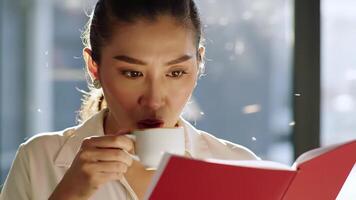 Woman Reading From a Red Book in Bright Room Sunlight video