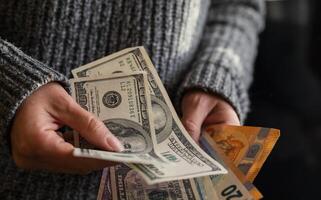 Girl holding a stack of dollar bills ready to pay or make a purchase confidently with cash in hand photo