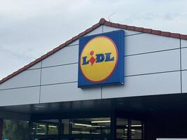 Warsaw, Poland - May 22, 2025 Lidl supermarket storefront featuring bright logo and modern architecture, showcasing retail shopping experience in urban environment with inviting entrance photo