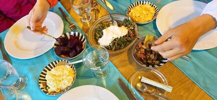 Hands reaching for various dishes on a beautifully set dining photo