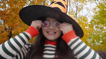 Happy child in witch hat enjoying halloween with costume and googly eyes video