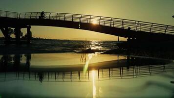 A Cyclist Silhouette Crossing a Bridge Over the Sea at Sunset video
