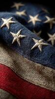 Textured American flag showcasing stars and stripes with intricate stitching in warm, natural lighting photo