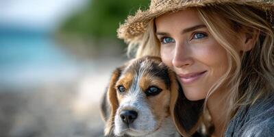 Woman with a beagle puppy enjoying a sunny day at the beach, smiling and embracing her furry friend photo