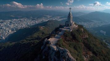 Landmark on mountain summit with cross overlooking cityscape and mountains during daylight photo