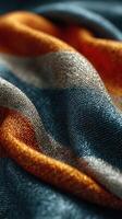 Colorful textile fabric display featuring vibrant stripes in blue, orange, and silver tones on soft surface photo