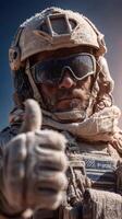 Soldier giving a thumbs up while covered in desert dust during a military operation in a war-torn region photo