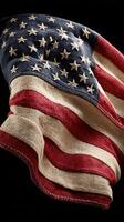 Waving American flag made of textured fabric displayed against a dark background photo