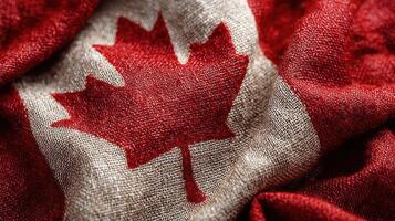 Canadian flag displayed prominently with bold colors and intricate textures at a cultural event during a sunny afternoon photo