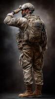 Soldier in military uniform saluting with a tactical backpack in a studio setting during a dramatic lighting session photo