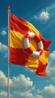 Decorative flag with lifebuoy design billows against a bright blue sky with fluffy clouds at a lakeside location photo