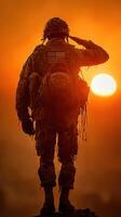 Soldier saluting at sunset in a tribute to bravery and sacrifice during military operations photo