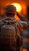 Soldier saluting at sunset while covered in frost during winter mission in a remote location photo