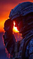 Soldier saluting at sunset with ice droplets on helmet in a cold environment photo