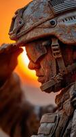 Soldier saluting at sunset with a dusty uniform and helmet during a mission in a desert environment photo