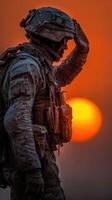 Soldier salutes at sunset during a cold mission in an icy environment photo