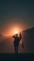 Soldier saluting at sunset in a mountainous landscape with a flag in hand photo