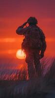 Soldier saluting at sunset on a beach, honoring the fallen while surrounded by tall grass and vibrant colors in the sky photo