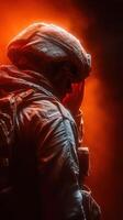 Soldier in armor reflects on his mission amidst a dramatic orange haze during nighttime operations photo