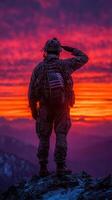 Soldier salutes against a vibrant sunset backdrop in a mountainous landscape photo