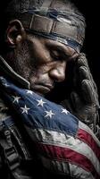 Soldier honoring fallen comrades while draped in American flag during a solemn moment of reflection photo