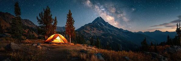 Stargazing night at a mountain campsite with a glowing tent under the Milky Way photo