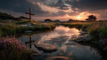 Sunset over tranquil waters with cross reflection in serene landscape near rocky outcrop photo