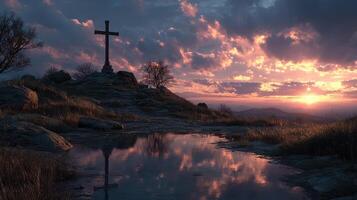 Serene sunset view behind a cross on a hilltop with calm water reflecting the sky colors photo