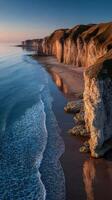 Majestic cliffs reflect in calm ocean waters during sunrise along the scenic coastline photo