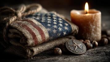 American flag fabric and a star badge placed next to a lit candle on a rustic wooden surface with decorative stones photo