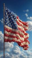 Waving American flag against a blue sky with fluffy clouds in the background creating a patriotic atmosphere photo