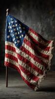 Vintage American flag on display with frayed edges, capturing a sense of history and patriotism in a rustic setting photo