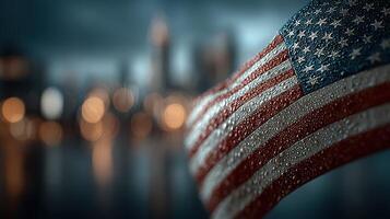American flag waves in the rain with blurred city skyline in the background during twilight hours photo