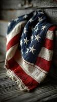 Old flag draped over rustic wood background evokes a sense of patriotism and nostalgia in warm, soft lighting photo