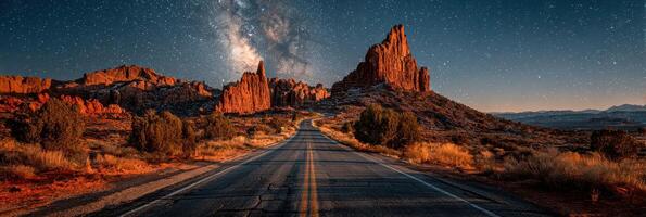 Starry night over winding road in rugged mountain landscape under vast sky photo