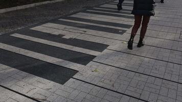 A woman confidently walks across a pedestrian crossing within a bustling urban setting video