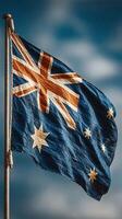 Flag of Australia waving against a blue sky with soft clouds during the day, showcasing national pride and identity photo