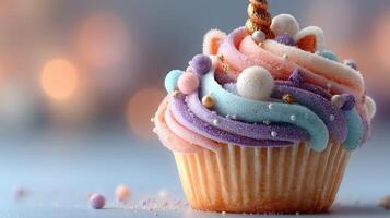 Colorful cupcake with swirled frosting and festive decorations sits on a surface at a celebration photo