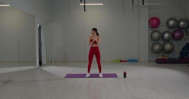 Girl practicing hand kneading exercises in a fitness studio during midday video