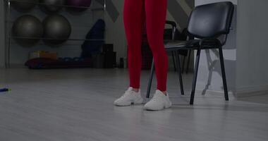 Leg raises with resistance band performed by a girl while sitting in a fitness studio during a workout session video