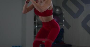 Girl performs squats and leg lifts in fitness studio during workout session focused on strength and flexibility video