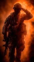 Soldier saluting in a dramatic orange haze during a military operation at sunset photo