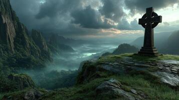 Celtic cross stands majestically on a rocky cliff overlooking misty mountains at dusk photo