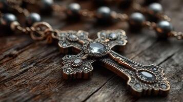Old decorative cross and rosary beads on wooden surface show craftsmanship and religious significance from a quiet moment of reflection photo