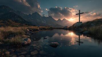 Majestic sunset over mountains with a cross by a tranquil pond reflecting the sky photo